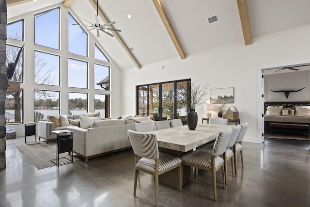 dining space featuring beam ceiling and high vaulted ceiling