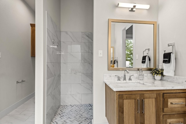 bathroom featuring tiled shower and vanity