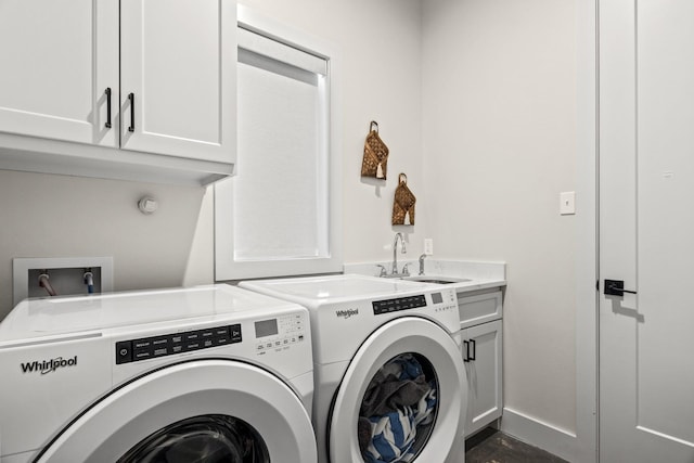 washroom featuring cabinets, washing machine and dryer, and sink