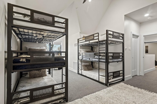 carpeted bedroom with high vaulted ceiling