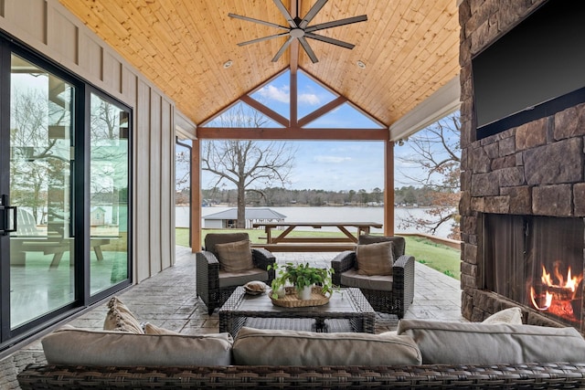 view of patio with an outdoor stone fireplace, ceiling fan, and a water view