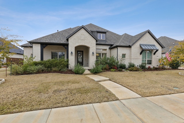 french country style house featuring a front yard and a porch