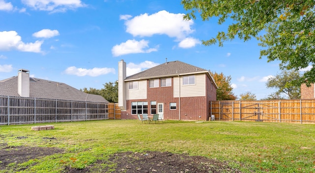 rear view of property with a yard