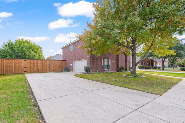 view of front of house featuring a garage, central AC unit, and a front yard