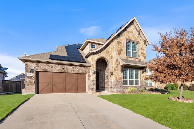 view of front of home featuring solar panels, a garage, and a front lawn