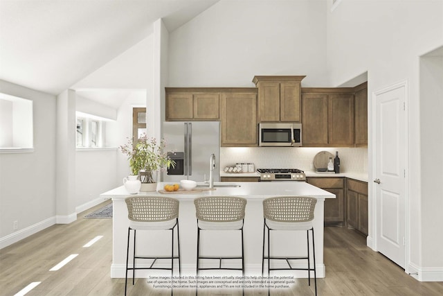 121 Red Cedar Ct, Balch Springs, TX 75181 - kitchen featuring stainless steel appliances, a sink, a kitchen breakfast bar, high vaulted ceiling, and a center island with sink