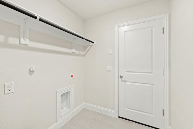 laundry area featuring hookup for an electric dryer, light tile patterned floors, laundry area, and baseboards
