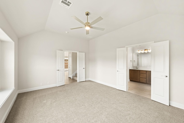 unfurnished bedroom with light colored carpet, ensuite bath, visible vents, lofted ceiling, and baseboards