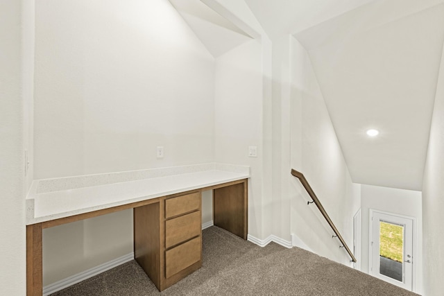unfurnished office featuring recessed lighting, dark colored carpet, built in desk, and baseboards