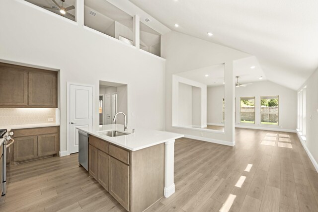 kitchen with dishwasher, a sink, light countertops, a ceiling fan, and a center island with sink