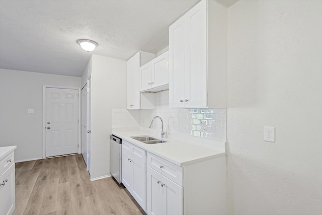 kitchen with dishwasher, sink, light hardwood / wood-style floors, decorative backsplash, and white cabinets