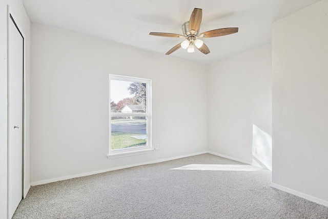 carpeted spare room with ceiling fan