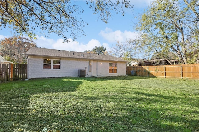 rear view of house with a lawn and cooling unit