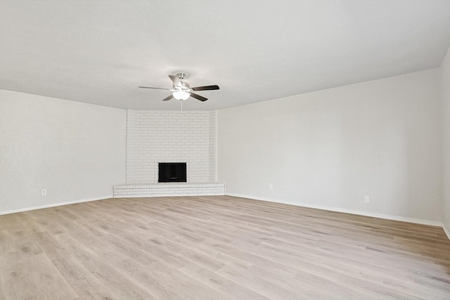 unfurnished living room with a fireplace, light hardwood / wood-style flooring, and ceiling fan