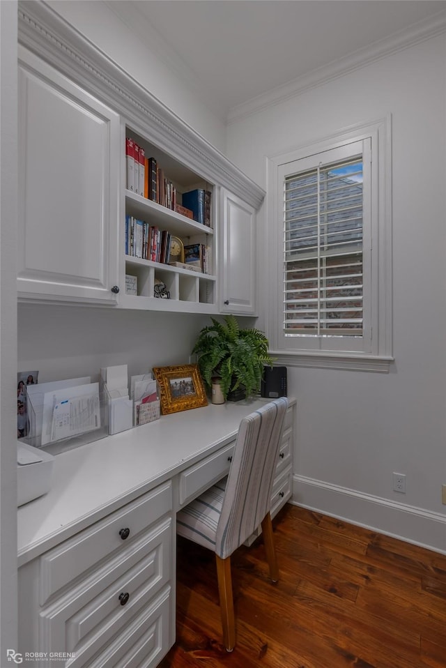 home office featuring ornamental molding, dark hardwood / wood-style floors, and built in desk