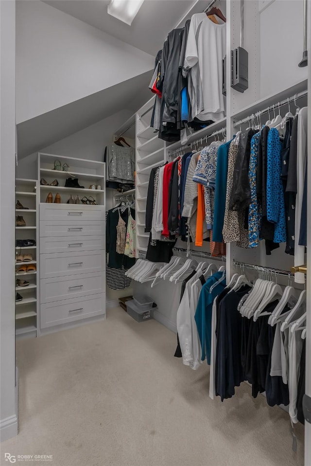 walk in closet with vaulted ceiling and carpet