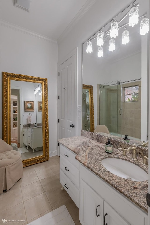 bathroom featuring a shower with door, crown molding, tile patterned flooring, and vanity