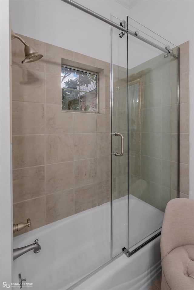 bathroom with bath / shower combo with glass door