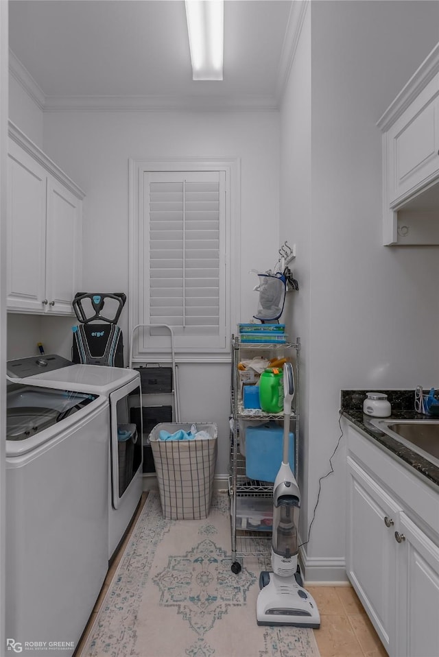 washroom with light tile patterned flooring, sink, cabinets, ornamental molding, and washer and clothes dryer