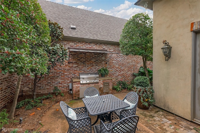 view of patio with area for grilling and a grill