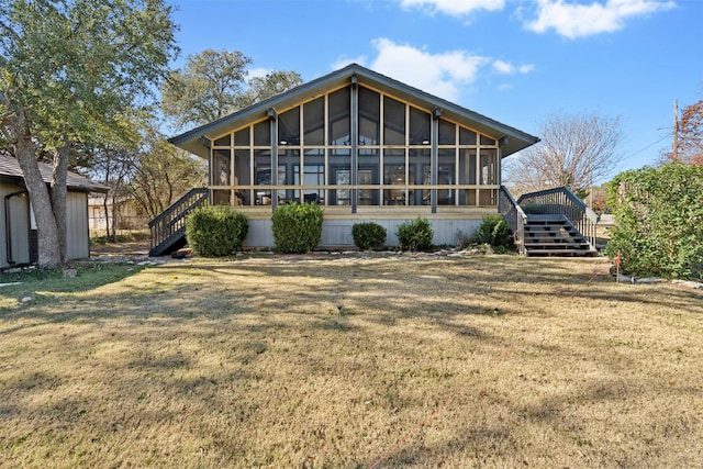 back of house featuring a deck and a lawn