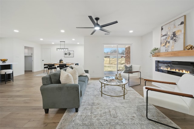 living room with ceiling fan and light hardwood / wood-style flooring