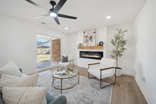 living room featuring ceiling fan and hardwood / wood-style flooring