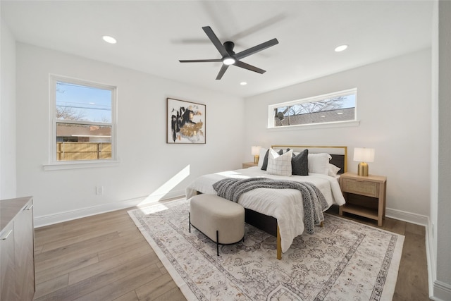 bedroom with multiple windows, ceiling fan, and light wood-type flooring