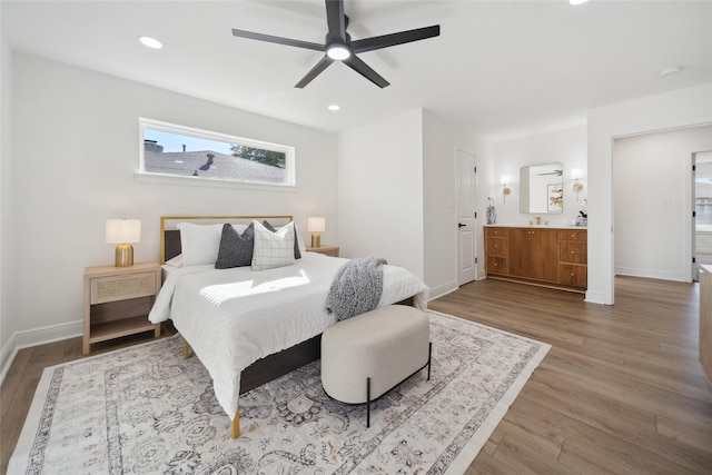 bedroom with hardwood / wood-style flooring, ceiling fan, and ensuite bath