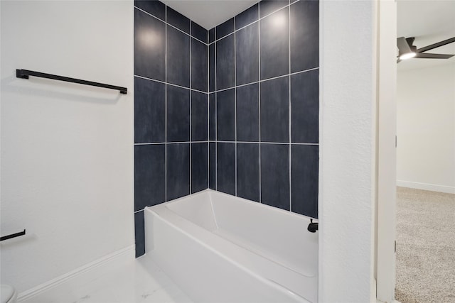 bathroom featuring ceiling fan and tiled shower / bath