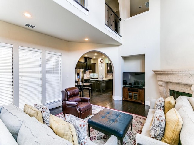 living room with dark wood-type flooring and a premium fireplace