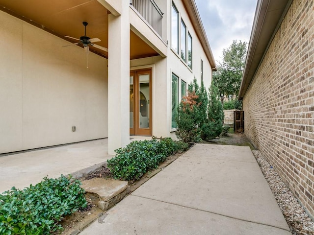 view of side of home featuring ceiling fan, a patio, and a balcony