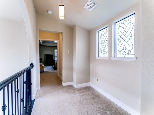 hallway featuring lofted ceiling and carpet floors