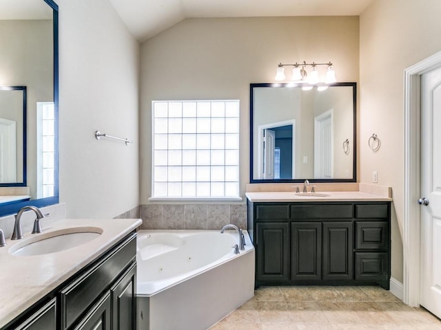 bathroom with lofted ceiling, vanity, tile patterned flooring, and a bathing tub