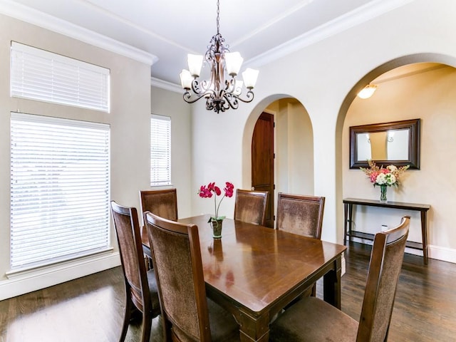 dining room featuring dark hardwood / wood-style flooring, an inviting chandelier, and crown molding