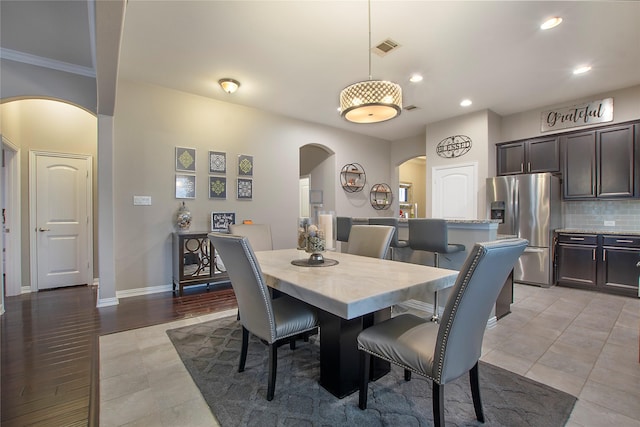 dining room with crown molding and light hardwood / wood-style flooring