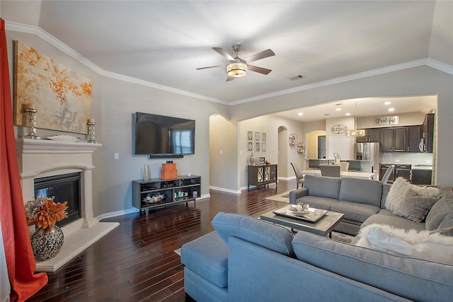 living room featuring ornamental molding, lofted ceiling, ceiling fan, and dark wood-type flooring