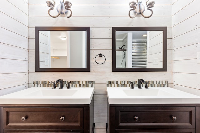 bathroom with vanity, an inviting chandelier, and wooden walls