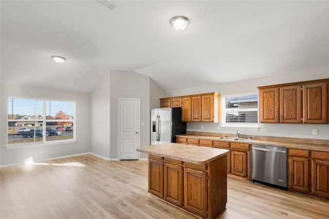 kitchen featuring sink, a center island, vaulted ceiling, light wood-type flooring, and stainless steel appliances