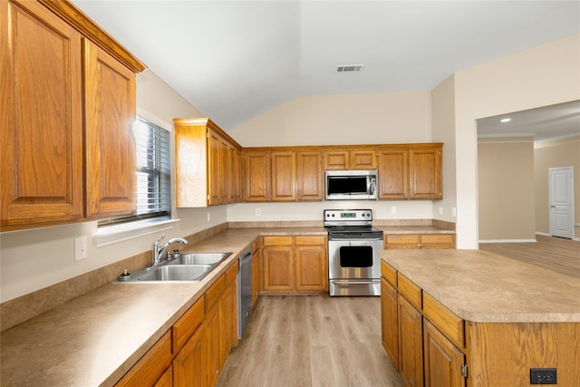 kitchen with sink, vaulted ceiling, stainless steel appliances, and light wood-type flooring