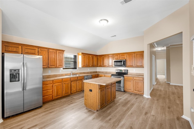 kitchen with a kitchen island, lofted ceiling, sink, light hardwood / wood-style floors, and stainless steel appliances