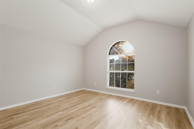 unfurnished room with lofted ceiling and light hardwood / wood-style floors