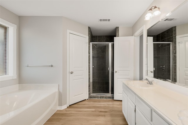 bathroom with vanity, wood-type flooring, and shower with separate bathtub