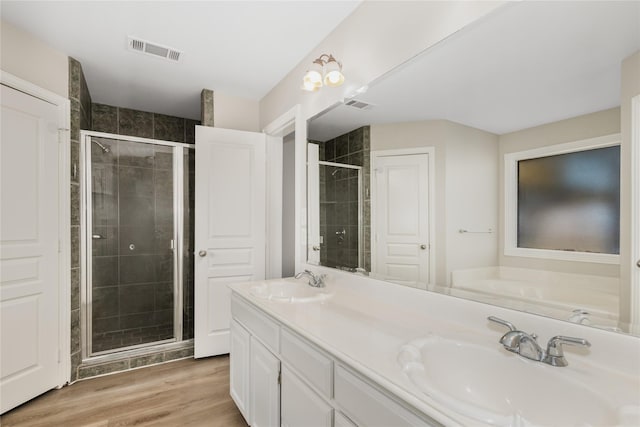 bathroom featuring vanity, wood-type flooring, and a shower with shower door