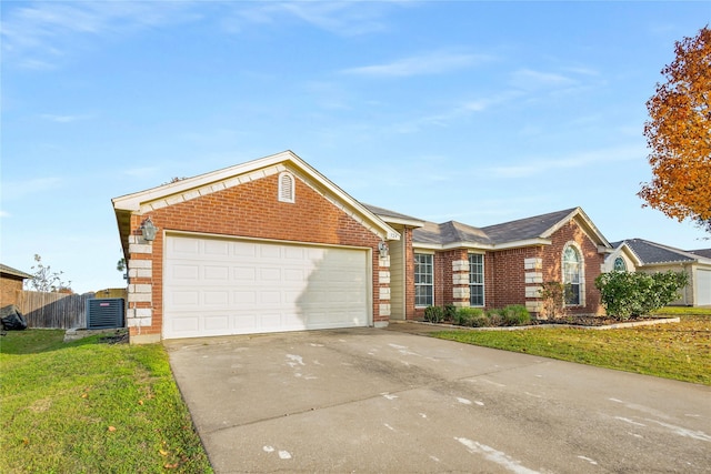 ranch-style home featuring a garage, a front lawn, and central air condition unit