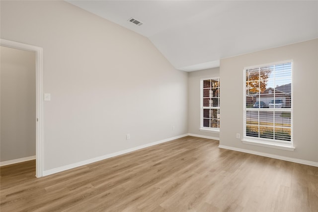 empty room with lofted ceiling and light hardwood / wood-style flooring