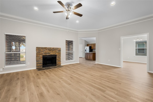 unfurnished living room featuring crown molding, a fireplace, and ceiling fan with notable chandelier