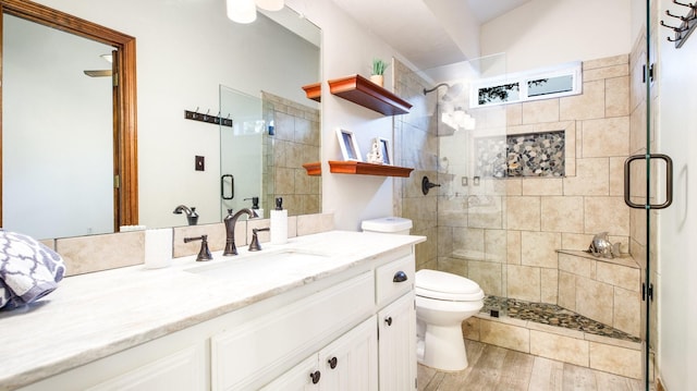 bathroom with vanity, toilet, a shower with shower door, and wood-type flooring