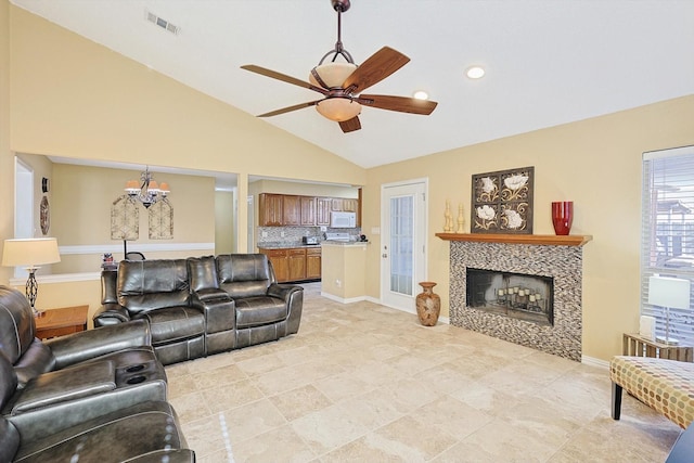 living room featuring high vaulted ceiling, ceiling fan, and a tiled fireplace