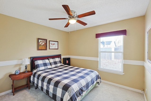 carpeted bedroom with ceiling fan and a textured ceiling